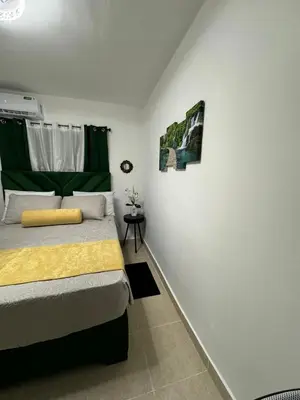 a bedroom with a bed with a yellow blanket at Sweet dreams Tropical paradise in San Isidro