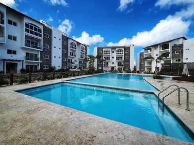 a large swimming pool in front of some buildings at Apartment w private terrace and Jacuzzi in Las Terrenas