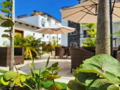 a patio with an umbrella and tables and chairs at Apartment w private terrace and Jacuzzi in Las Terrenas