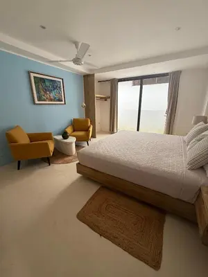 a bedroom with a bed and two chairs and a window at Kainos Tropical Boutique Hotel in Las Terrenas