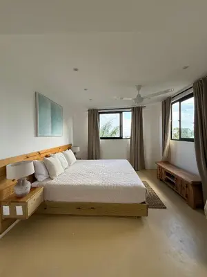 a bedroom with a large bed and two windows at Kainos Tropical Boutique Hotel in Las Terrenas