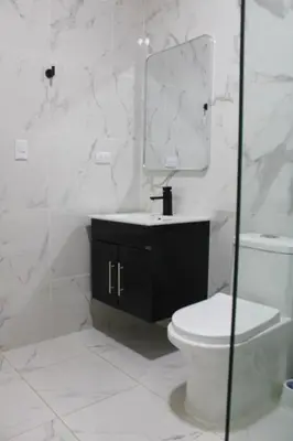 a bathroom with a toilet and a sink and a mirror at Acogedor apartamento a cerca de la playa in San Felipe de Puerto Plata
