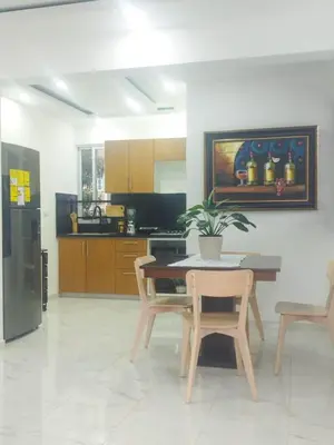 a kitchen with a table and two chairs and a table at Acogedor apartamento a cerca de la playa in San Felipe de Puerto Plata