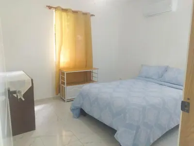 a bedroom with a bed and a night stand at Acogedor apartamento a cerca de la playa in San Felipe de Puerto Plata