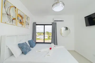 a living room with a white couch and a window at Cozy 2BR Apartment in Sunshine Bayahibe in San Rafael del Yuma