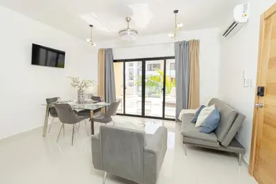 a living room with a table and a chair at Cozy 2BR Apartment in Sunshine Bayahibe in San Rafael del Yuma