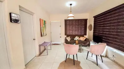 a living room with pink chairs and a couch at Apartamento de 2 habitaciones in Colorado