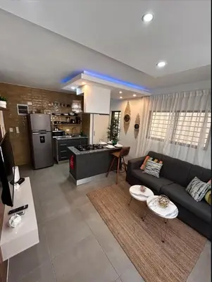 a living room with a couch and a kitchen at Casa Estrellita-Romantic getaway in Santo Domingo