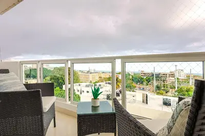 a living room with a couch and a table and windows at Cozy City Center 2BD Condo, in Santo Domingo