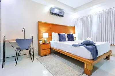 a bedroom with a bed and a desk and a chair at Cozy City Center 2BD Condo, in Santo Domingo