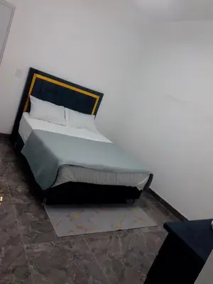 a bed in a room with a white wall at Hotel Doña kila in El Catey