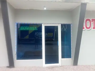 a glass door in a building with a sign on it at Hotel Doña kila in El Catey