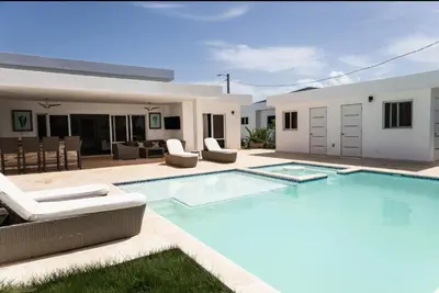 a swimming pool with chairs and a house at My luxury villa in Sosúa