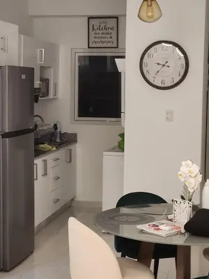 a kitchen with a table and a clock on the wall at Paraíso encantado Juan Dolio, Confort y Seguridad in Villas del Mar