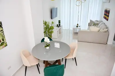a white living room with a table and chairs at Paraíso encantado Juan Dolio, Confort y Seguridad in Villas del Mar
