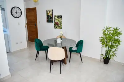 a dining room with a table and green chairs at Paraíso encantado Juan Dolio, Confort y Seguridad in Villas del Mar