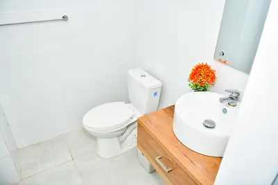 a white bathroom with a toilet and a sink at Paraíso encantado Juan Dolio, Confort y Seguridad in Villas del Mar