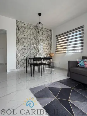 a living room with a table and a couch at Bright & Airy Apartment in Bayahibe