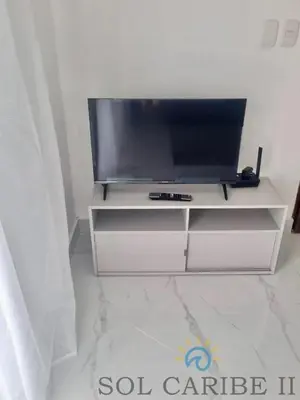 a white entertainment center with a flat screen tv on it at Bright & Airy Apartment in Bayahibe