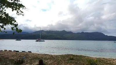 a boat on a lake with mountains in the background at Villa Sol de Campo in Las Galeras
