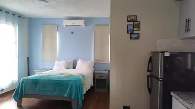 a small bedroom with a bed and a refrigerator at Villa Sol de Campo in Las Galeras
