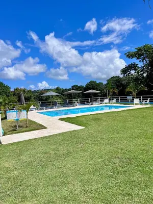 a swimming pool with grass and umbrellas at Sky Golden in Los Altos de Jalisco