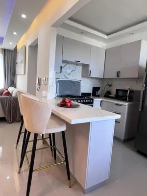 a kitchen with white cabinets and a counter with chairs at Sky Golden in Los Altos de Jalisco