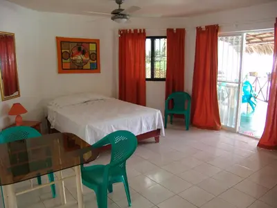 a bedroom with a bed and a table and chairs at Surf & Stay Waveriders, Encuentro in Cabarete