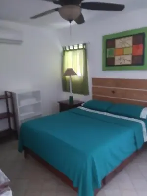 a bedroom with a blue bed and a ceiling fan at Surf & Stay Waveriders, Encuentro in Cabarete
