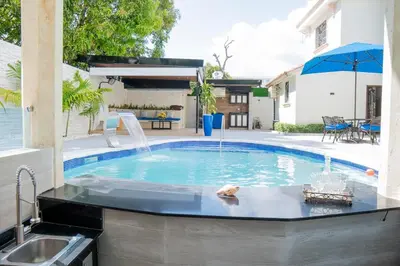 a swimming pool with a fountain in a backyard at Villa La Dueña - Vista Hermosa Luxury Retreat, 5BR Villa with Pool, Swim-Up Bar, Jacuzzi, Chef's Kitchen, Fast Wi-Fi, Full AC, EV Charger and Solar Power, Ideal for Families & Groups in Cancino