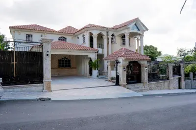 a white house with a gate and a fence at Villa La Dueña - Vista Hermosa Luxury Retreat, 5BR Villa with Pool, Swim-Up Bar, Jacuzzi, Chef's Kitchen, Fast Wi-Fi, Full AC, EV Charger and Solar Power, Ideal for Families & Groups in Cancino