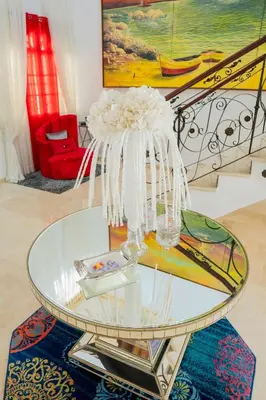 a glass table with a vase on top of it at Villa La Dueña - Vista Hermosa Luxury Retreat, 5BR Villa with Pool, Swim-Up Bar, Jacuzzi, Chef's Kitchen, Fast Wi-Fi, Full AC, EV Charger and Solar Power, Ideal for Families & Groups in Cancino