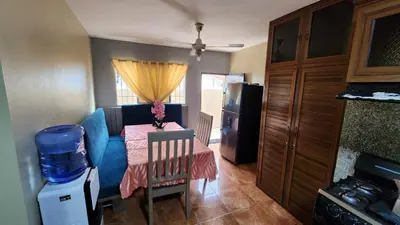a small kitchen with a table and a blue couch at Airbnbbuenhogar in Concepción de La Vega