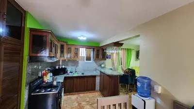 a kitchen with wooden cabinets and a black stove at Airbnbbuenhogar in Concepción de La Vega
