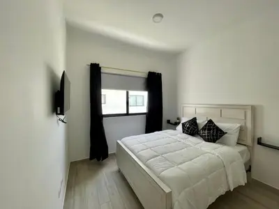a bedroom with a white bed and a window at Casa Lulu in Punta Cana