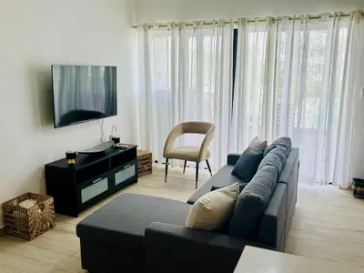 a living room with a couch and a tv at Casa Lulu in Punta Cana