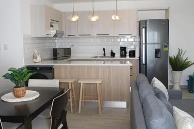 a kitchen and living room with a couch and a table at Casa Lulu in Punta Cana