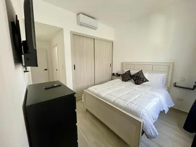 a bedroom with a bed and a flat screen tv at Casa Lulu in Punta Cana