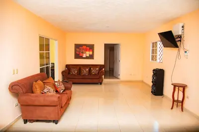 a living room with two couches and a flat screen tv at Boom Ranch in Las Galeras
