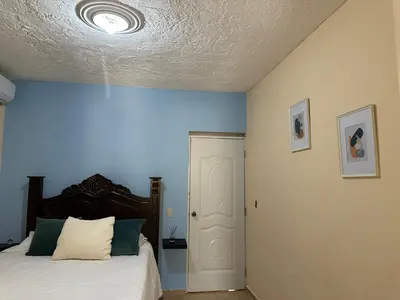 a bedroom with a bed with a blue wall at Casa Kaibana - 8 Pax, con piscina, cerca del mar in Las Galeras