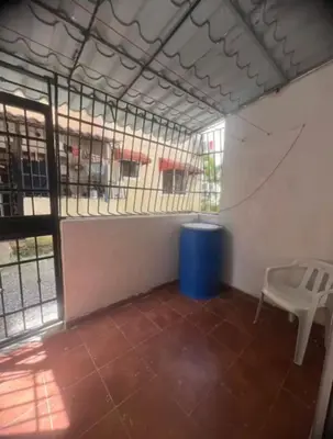 a cage with a chair and a blue trash can at Tú hogar en ciudad Juan Bosch in Los Paredones