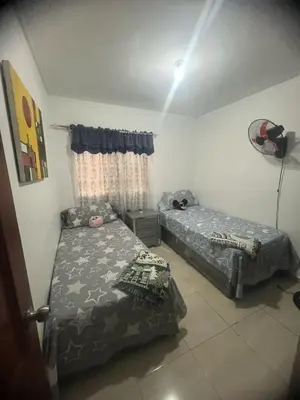 a bedroom with two beds and a window at Tú hogar en ciudad Juan Bosch in Los Paredones