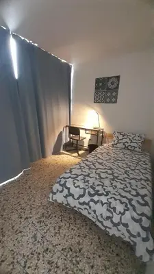 a bedroom with a bed and a table with a lamp at Apartment in the heart of the DISTRITO NACIONAL in Santo Domingo
