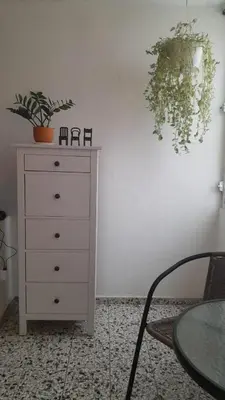 a white dresser with a table and a plant on a wall at Apartment in the heart of the DISTRITO NACIONAL in Santo Domingo