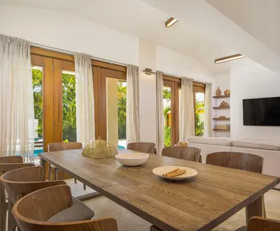 a dining room with a wooden table and chairs at Tropical Roga Villa with Private Pool in Cabarete