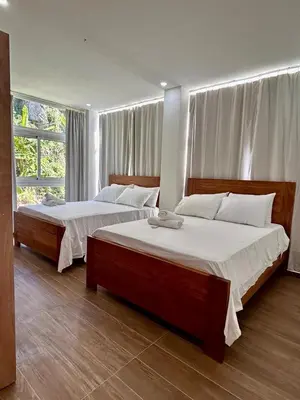 a bedroom with two beds and a large window at Refugio Verde Las Terrenas in Las Terrenas