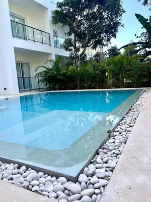 a swimming pool with rocks next to a building at Refugio Verde Las Terrenas in Las Terrenas