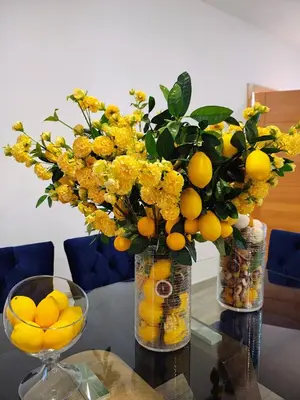 two vases with yellow flowers and oranges on a table at Sunflower Bayahibe with pool in Bayahibe