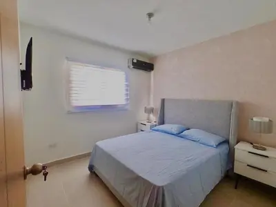 a bedroom with a bed with blue pillows and a window at The Chic Hideout full apt in san isidro Terrace in Juan López