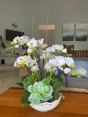 a vase filled with white flowers on a table at La Mansion en SAJOMA Villa 15 3br with private Pool in San José de Las Matas